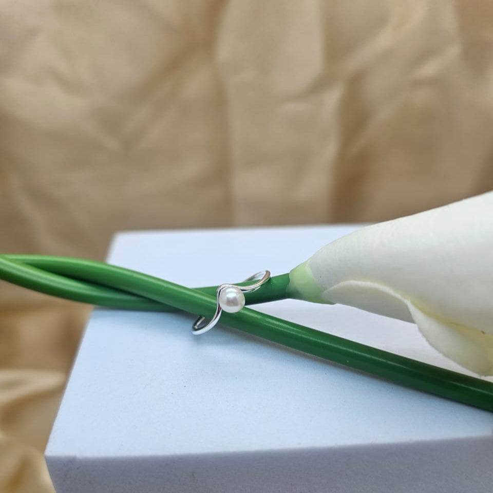 Pearl necklace on a white stand with a blurred beige background