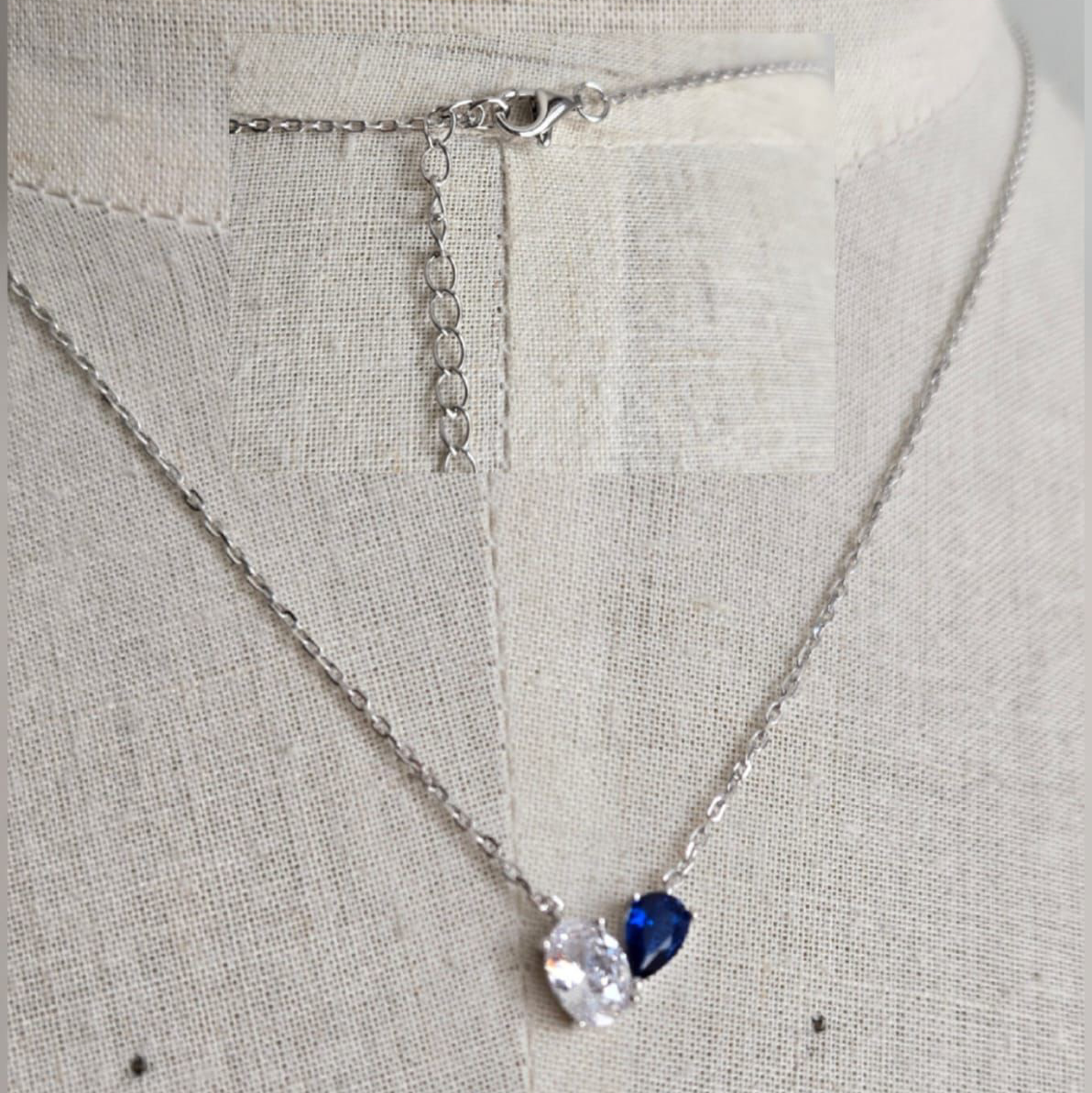 Necklace with a heart-shaped blue gemstone pendant on a light gray background