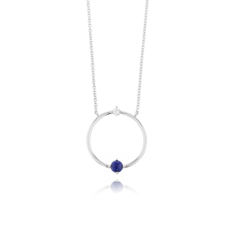 Silver necklace with a circular pendant and blue gemstone on a white background