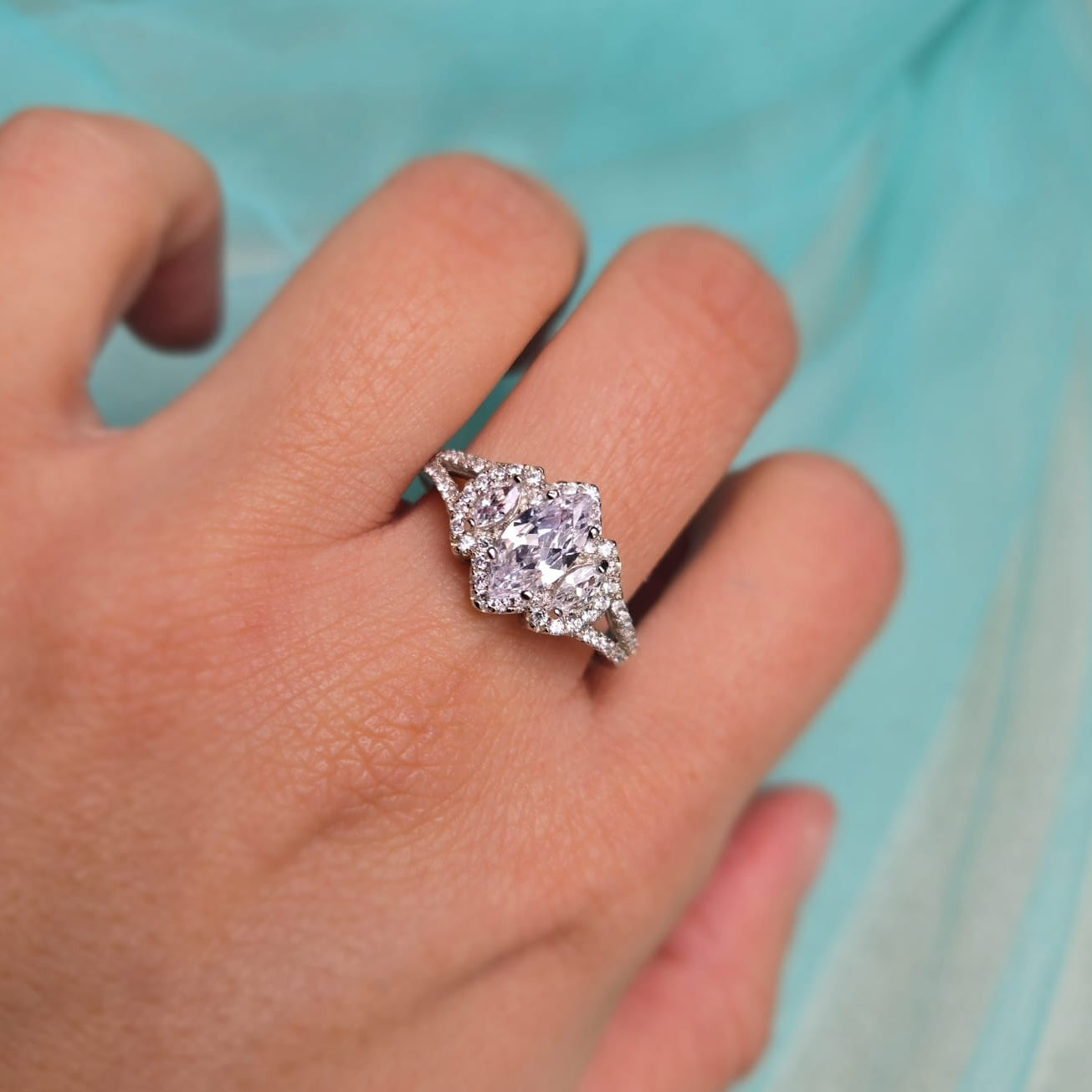 Diamond ring on a person's finger with a light blue background