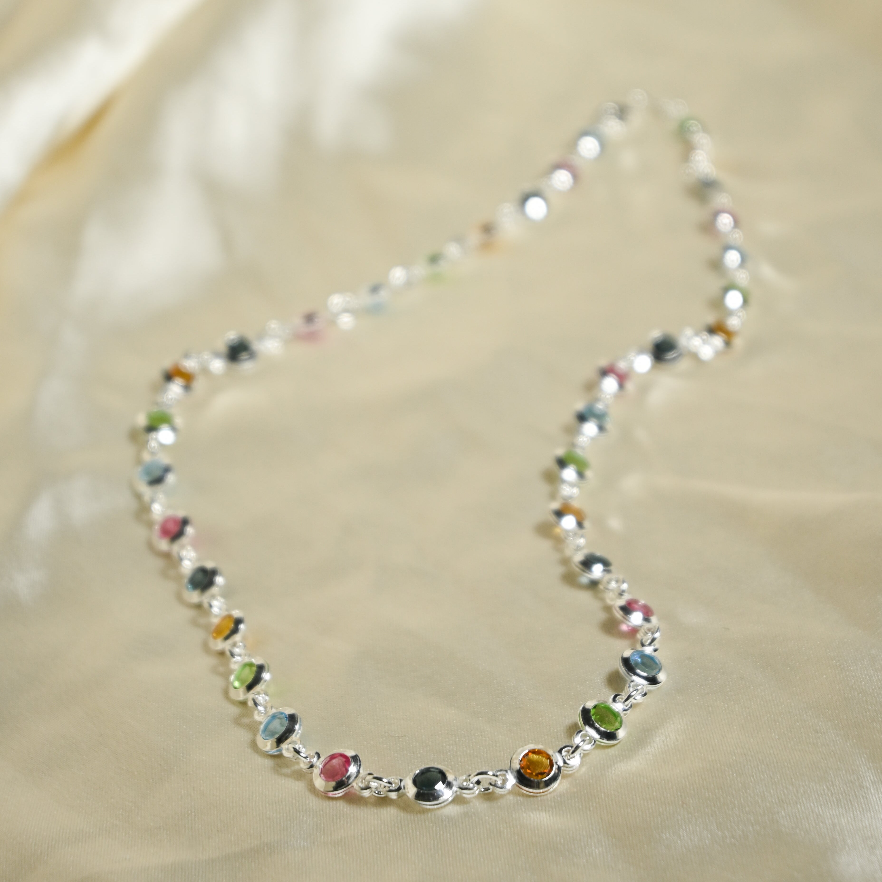 Necklace with multicolored beads on a beige fabric background