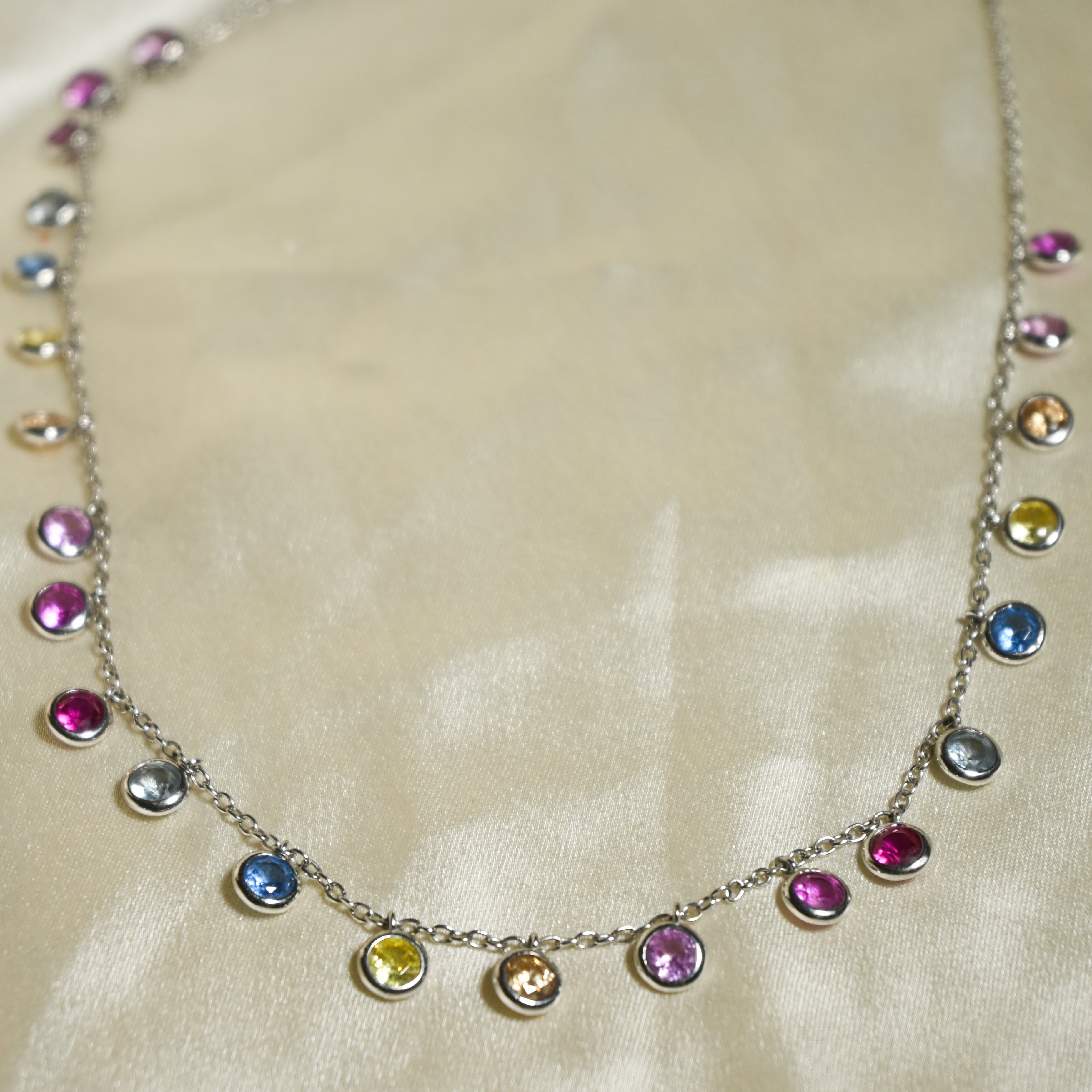 Necklace with multicolored gemstones on a beige fabric background