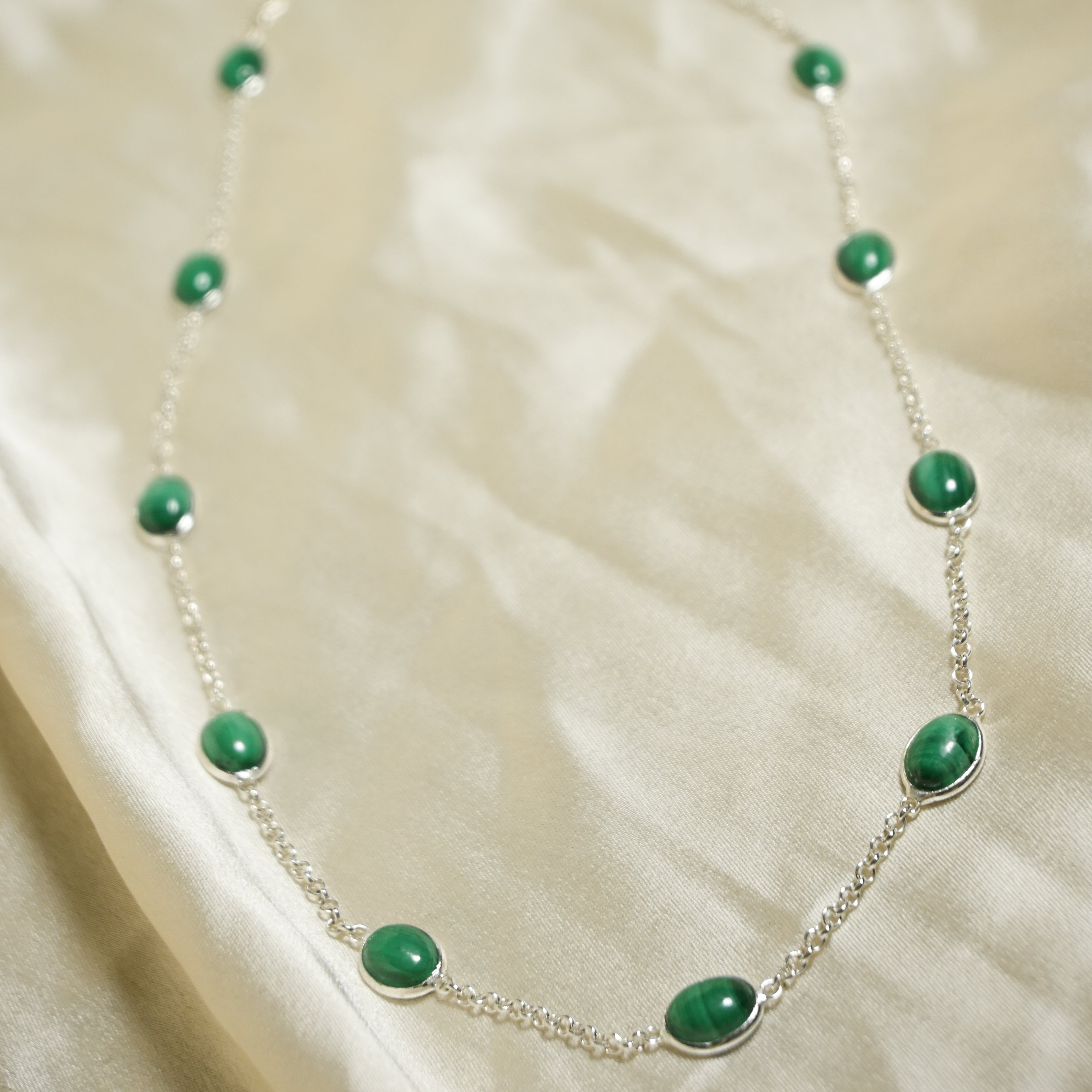 Necklace with green beads on a beige fabric background