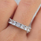 Diamond ring on a finger with a neutral background