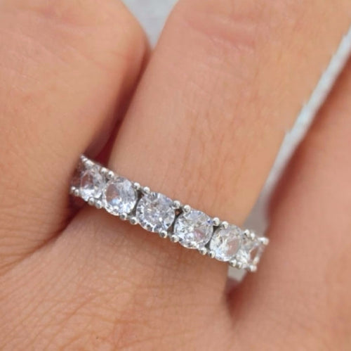 Diamond ring on a finger with a neutral background