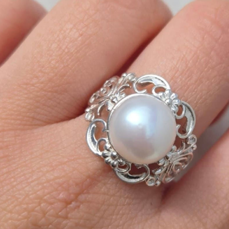 Silver ring with a pearl on a hand