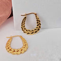 Gold hoop earrings on a light gray background