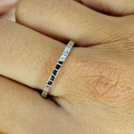 A sterling silver stripe band ring worn on a person's finger, showing a close-up of the ring on the hand.