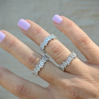 Hand wearing two silver rings with a blurred background