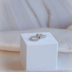 Two silver rings on a white cube with a soft blurred background