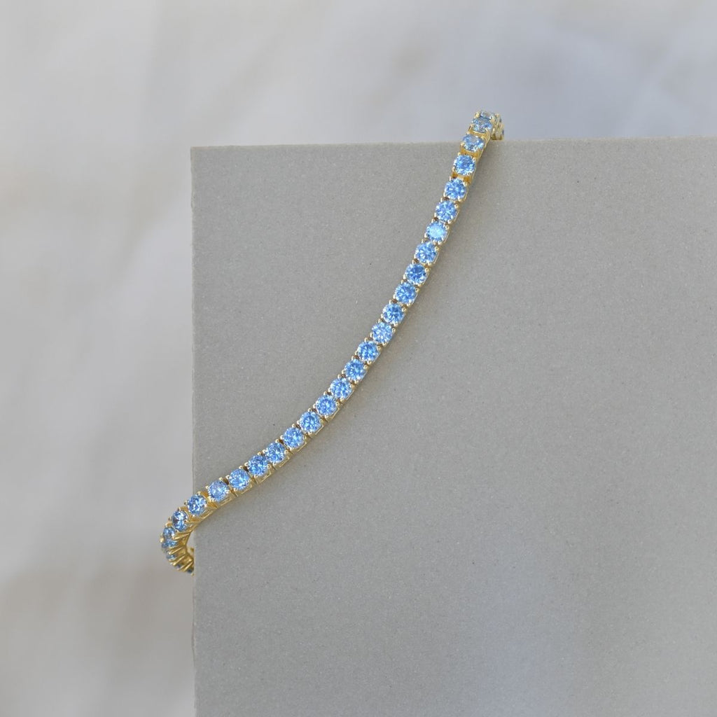 Gold tennis bracelet with blue zirconia stones