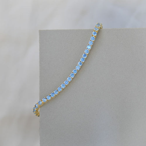 Gold tennis bracelet with blue zirconia stones