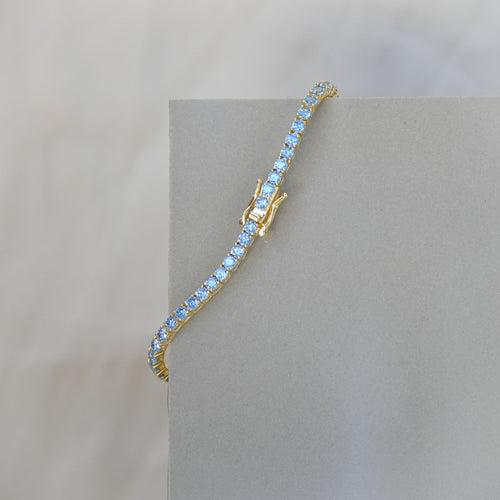 Gold tennis bracelet with blue zirconia stones