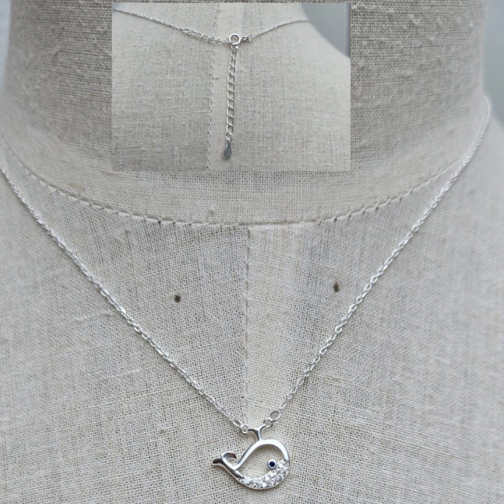 Silver necklace with a unique pendant on a mannequin.