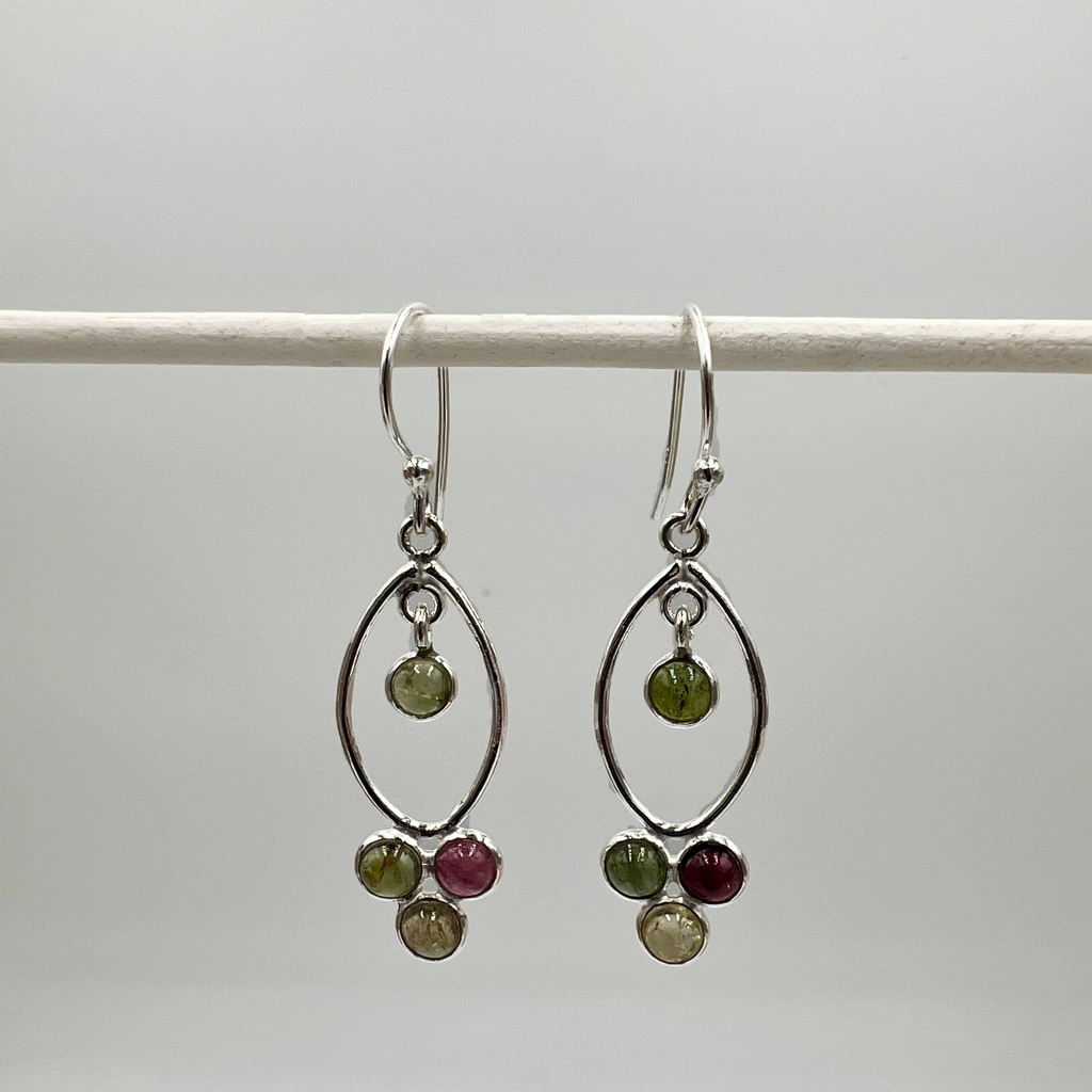A pair of sterling silver drop earrings with green and purple tourmaline semi precious stones, displayed against a white background.