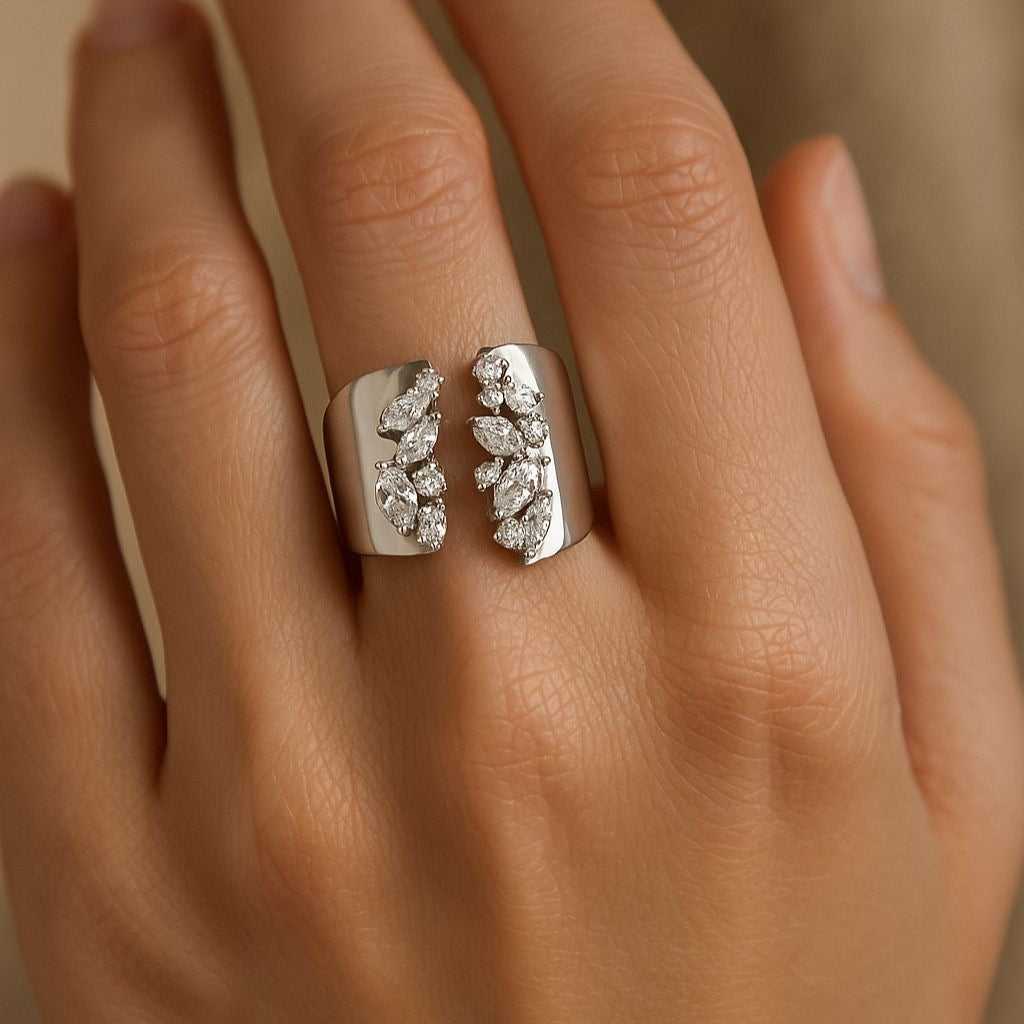 A sterling silver ring with cubic zirconia detailing, worn on a person's finger.