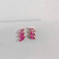 Pair of pink marquise-shaped earrings on a light gray background