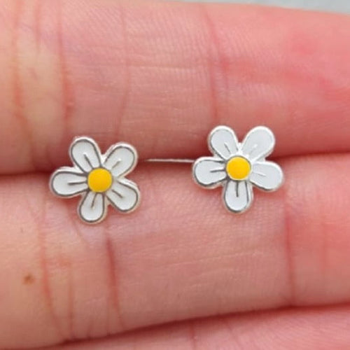 Flower-shaped earrings on a hand