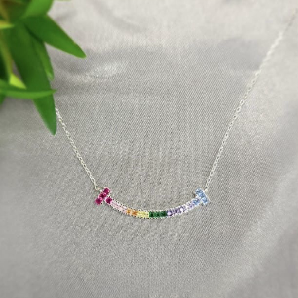 A sterling silver necklace with a bar pendant featuring a spectrum of rainbow-colored cubic zirconia.