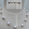 Pearl necklace on a mannequin with a close-up of the necklace in the background.