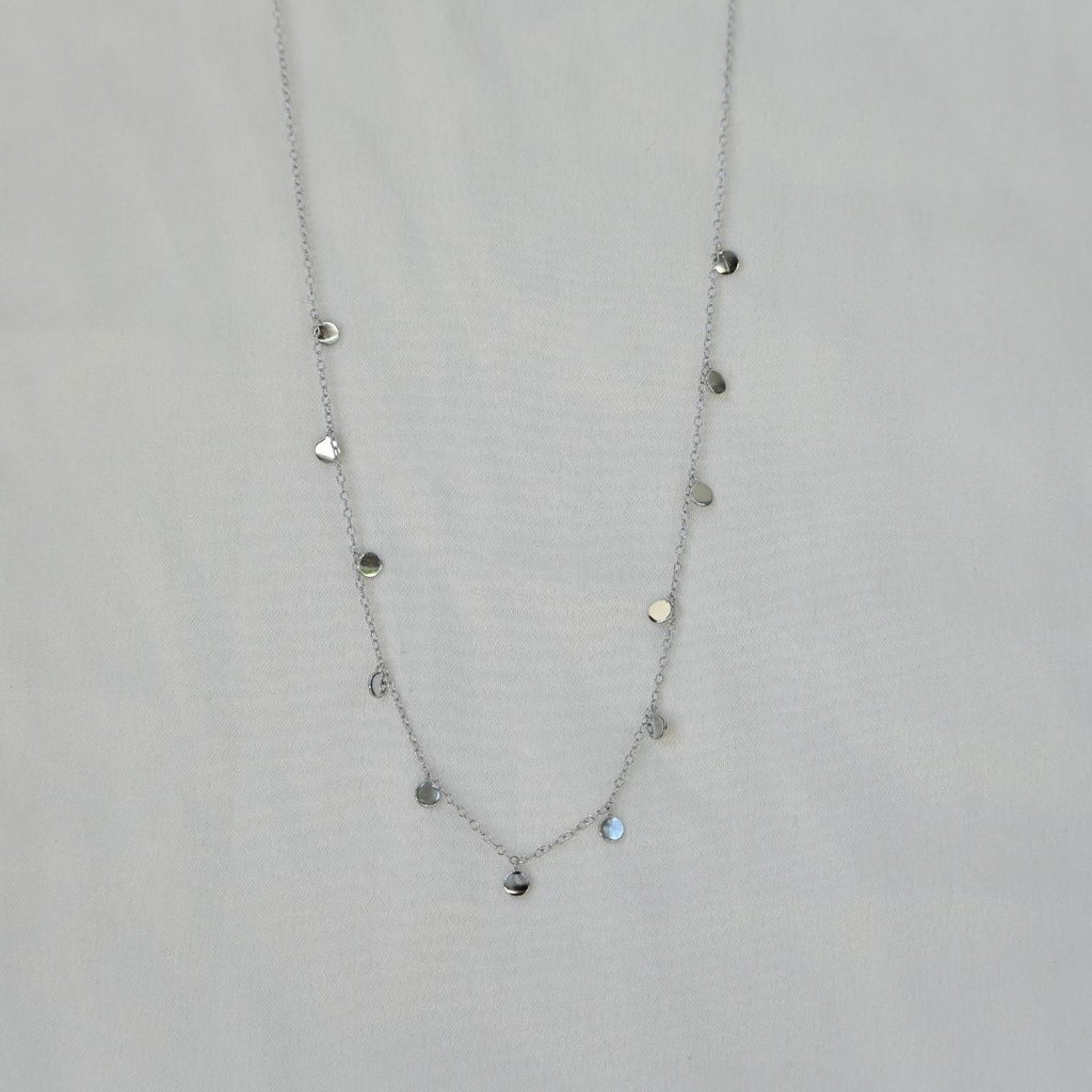 Silver necklace with heart-shaped pendants on a light gray background
