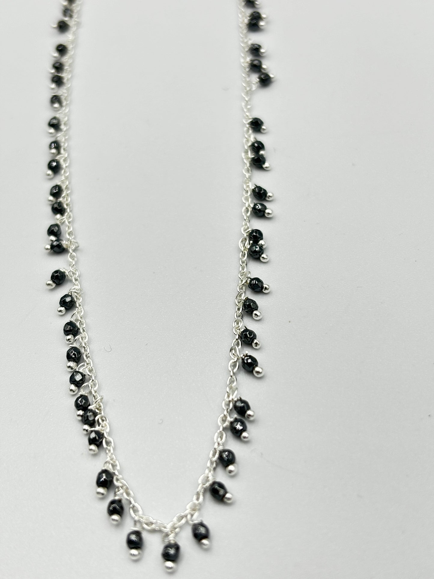 Sterling silver necklace with lots of hematite semi precious stones dangling on it