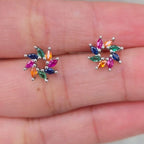 Colorful gemstone earrings on a person's hand