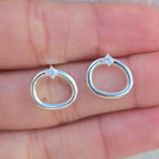 Silver hoop earrings with diamonds on a hand
