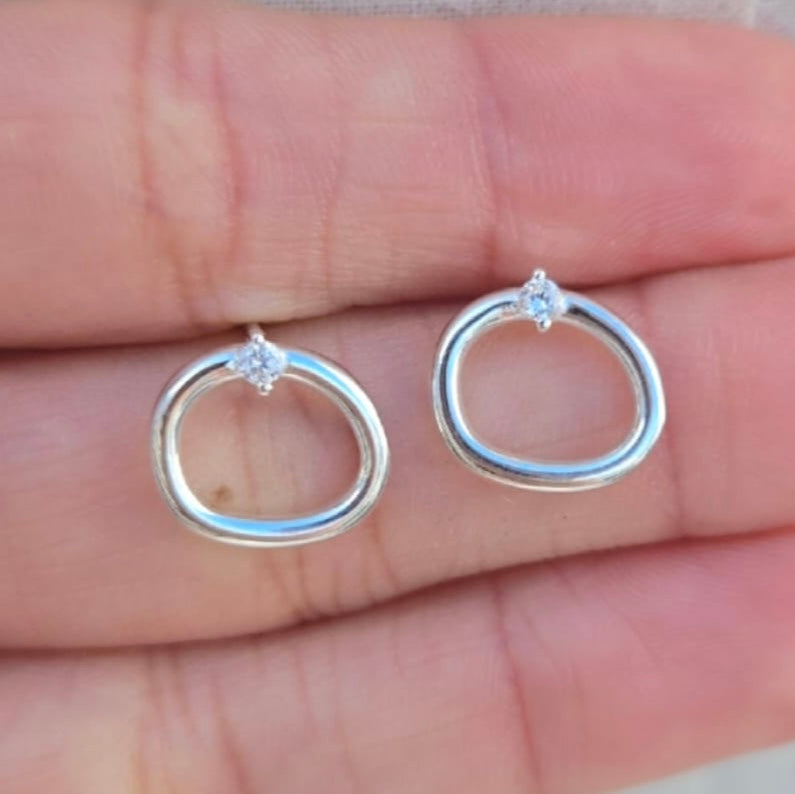 Silver hoop earrings with diamonds on a hand