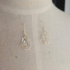 Silver teardrop earrings on a mannequin bust.