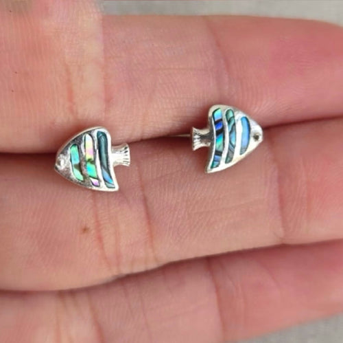 Fish-shaped earrings on a person's finger