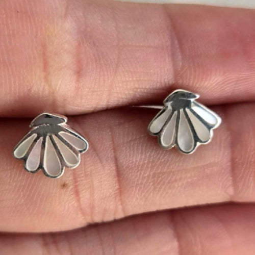 Silver floral earrings on a person's finger