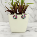 A pair of sterling silver circle drop earrings with multicolored cubic zirconia stones displayed in a white container.