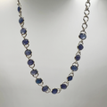 A sterling silver bracelet with multiple oval-shaped tanzanite semi-precious stone drops.