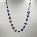 A sterling silver bracelet with multiple oval-shaped tanzanite semi-precious stone drops.