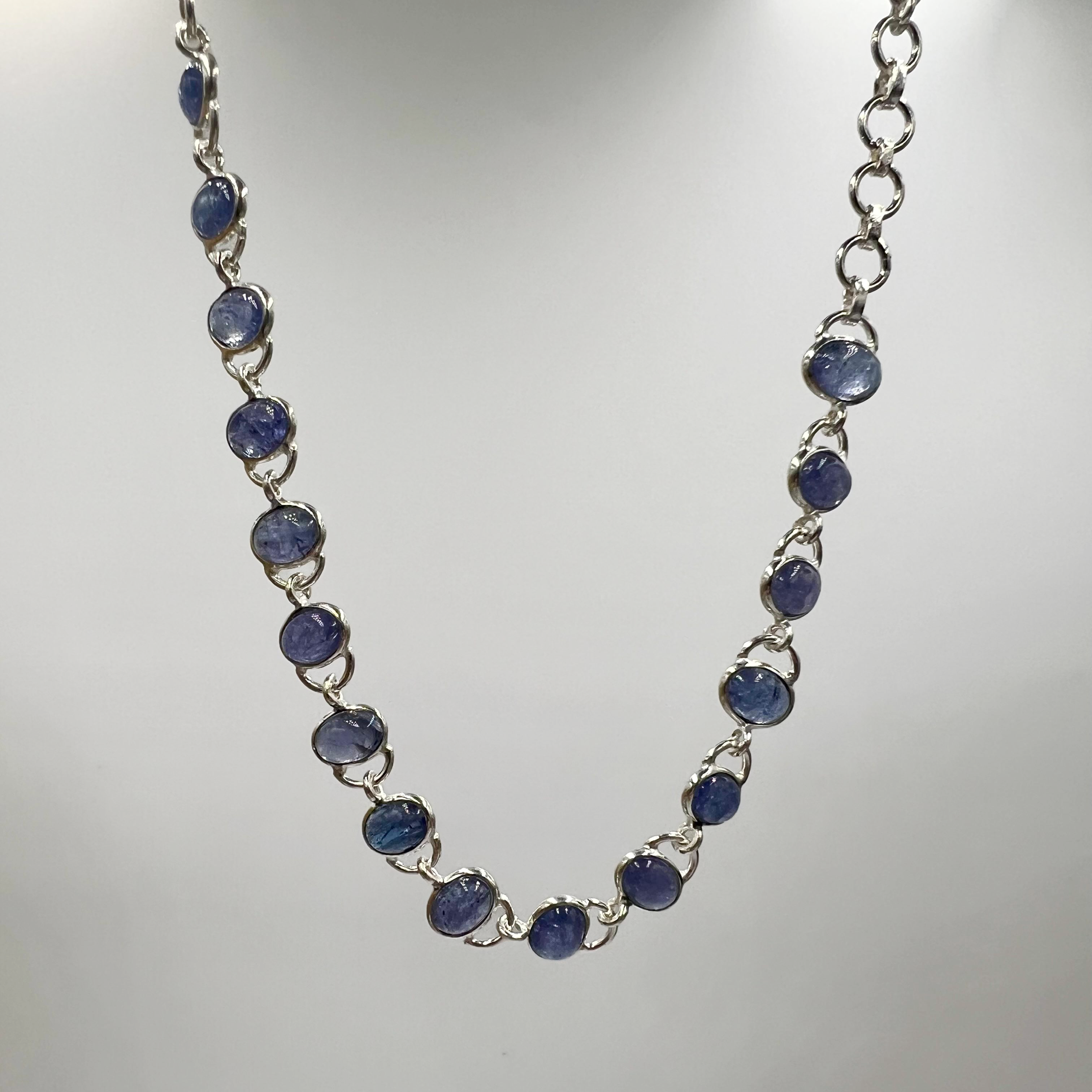 A sterling silver bracelet with multiple oval-shaped tanzanite semi-precious stone drops.