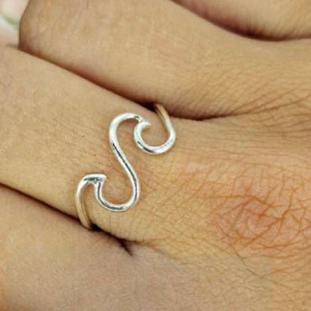 A sterling silver double wave ring on a person's finger, showing a simple yet elegant design.