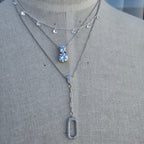 Necklace with floral and rectangular pendants on a mannequin