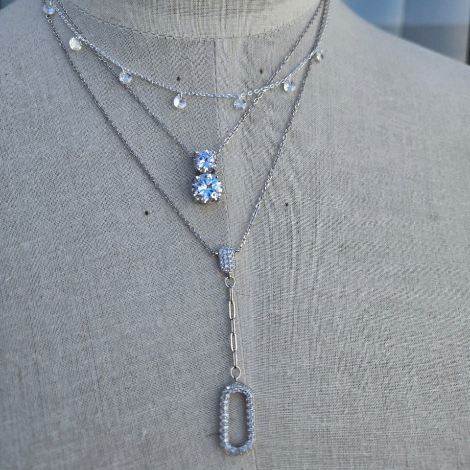 Necklace with floral and rectangular pendants on a mannequin