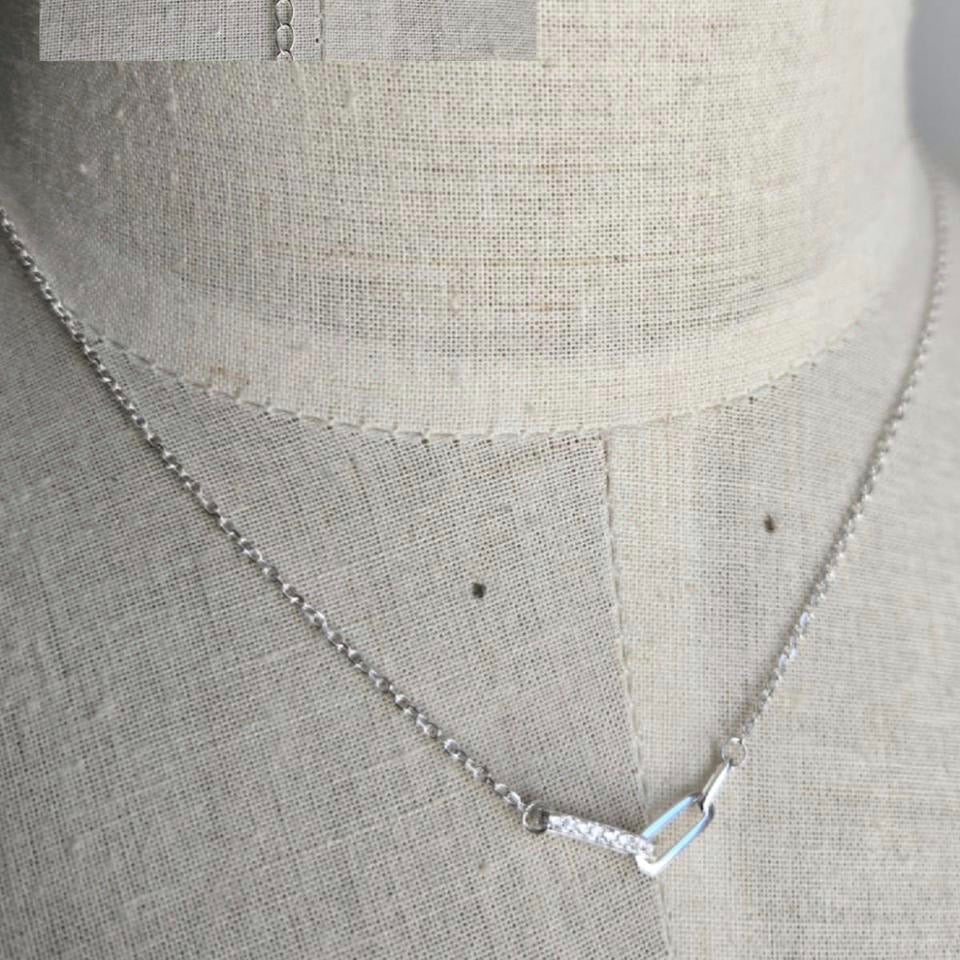 Silver necklace on a gray fabric background