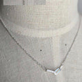 Silver necklace on a gray fabric background