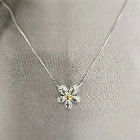 A sterling silver necklace with a flower slider pendant, displayed on a mannequin.