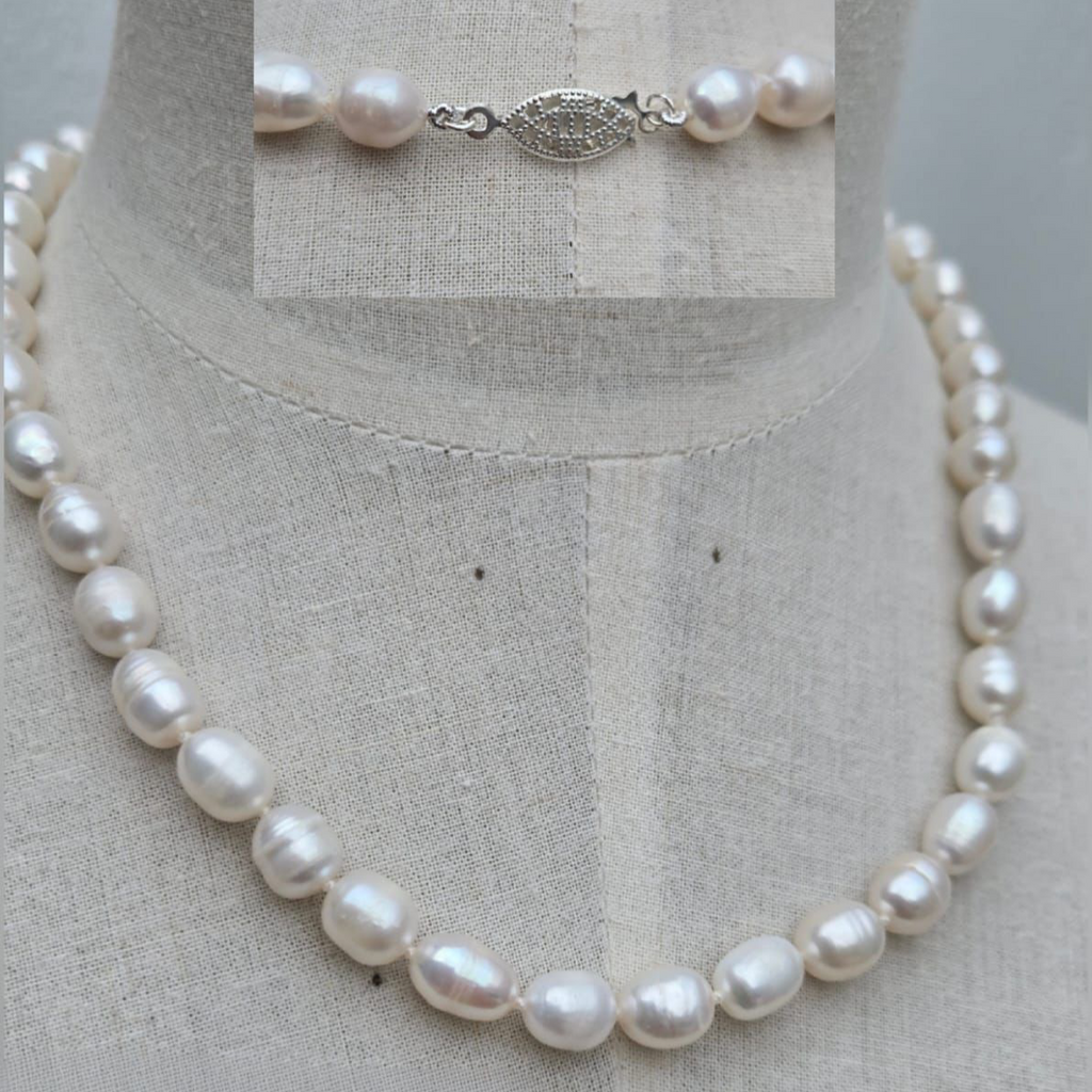 Pearl necklace on a mannequin with a close-up of the clasp on a gray background