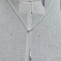 Silver necklace with a pendant on a gray fabric background