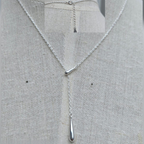 Silver necklace with a pendant on a gray fabric background