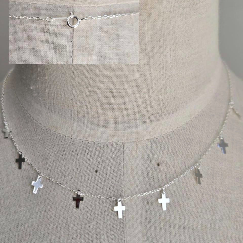 Necklace with cross pendants on a textured surface