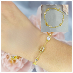 A gold-plated sterling silver bracelet with clear cubic zirconia stones, displayed on a person's wrist.