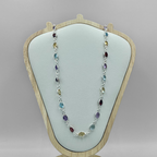 A semi-precious stone necklace with multiple colors displayed on a wooden stand.