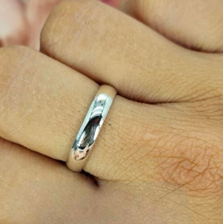 A sterling silver ring band on a person's finger, showing a simple and elegant design.