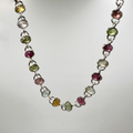A sterling silver bracelet with numerous oval tourmaline drops, displayed against a white background.